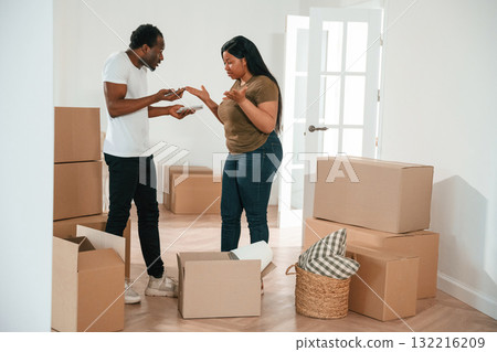 Having a quarrel. African American couple are moving into new house Having a quarrel. African American couple are moving into new house 132216209