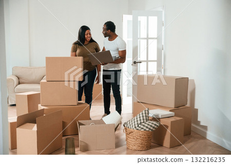 Wireless device, using laptop. African American couple are moving into new house 132216235