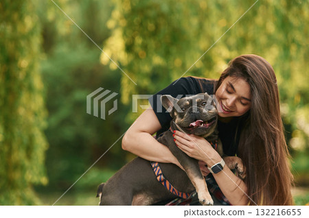 Embracing the animal. Young pretty woman is with her dog in the park Embracing the animal. Young pretty woman is with her dog in the park 132216655