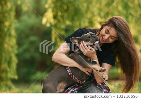 Embracing the animal. Young pretty woman is with her dog in the park Embracing the animal. Young pretty woman is with her dog in the park 132216656