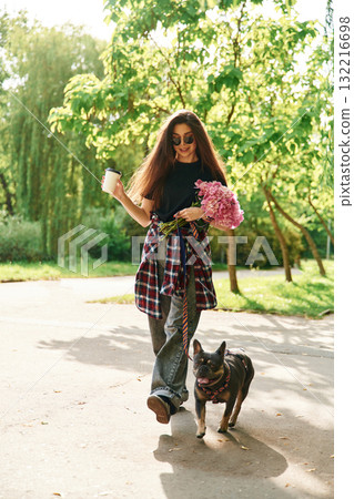Hawing a walk. Young pretty woman is with her dog in the park Hawing a walk. Young pretty woman is with her dog in the park 132216698