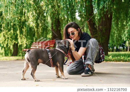 Weekend activities. Young pretty woman is with her dog in the park 132216700
