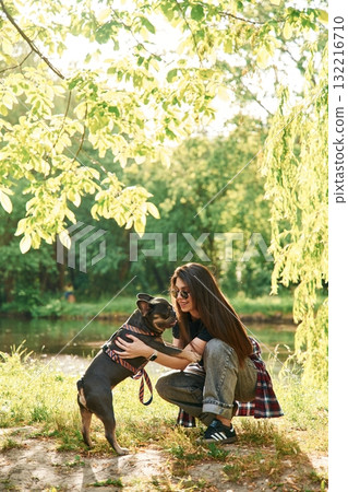 Lovely picture, sitting. Young pretty woman is with her dog in the park 132216710
