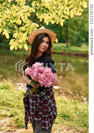 Beautiful young woman is with pink flowers in the park Beautiful young woman is with pink flowers in the park 132216720