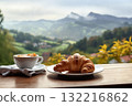 a cup of coffee and a fresh croissant on the table with a view of a beautiful landscape, still life, mountains and forest, haze at dawn 132216862