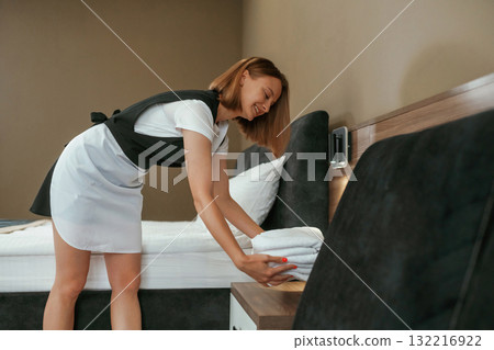 New fresh cloth. Young chambermaid is in hotel room New fresh cloth. Young chambermaid is in hotel room 132216922