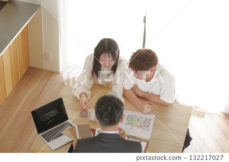 一對年輕夫婦與銷售員討論房屋建造 132217027