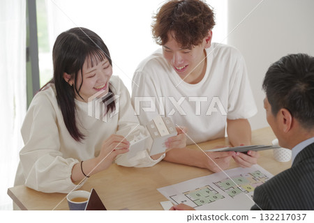 A young couple discussing house building with a salesman A young couple discussing house building with a salesman 132217037