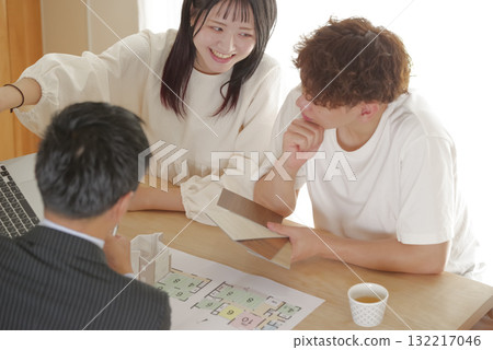 一對年輕夫婦與銷售員討論房屋建造 132217046