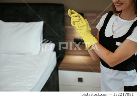 Wearing the yellow gloves. Young chambermaid is in hotel room Wearing the yellow gloves. Young chambermaid is in hotel room 132217091