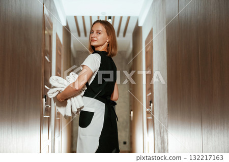 Ready for work. Chambermaid is standing in the hotel corridor Ready for work. Chambermaid is standing in the hotel corridor 132217163