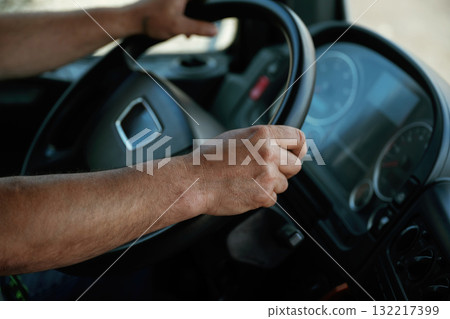 Close-up of hands gripping steering wheel of a truck 132217399