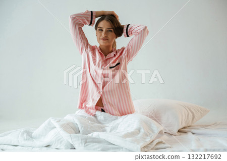 Rest conception, waking up, on the white blanket. Young pretty woman is against background in the studio 132217692