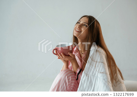 Big cup of drink. Morning, waking up. Young pretty woman is against background in the studio Big cup of drink. Morning, waking up. Young pretty woman is against background in the studio 132217699