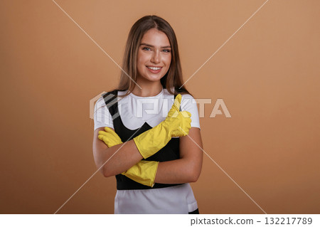 Against background, chambermaid at work. Young pretty woman is in the studio Against background, chambermaid at work. Young pretty woman is in the studio 132217789