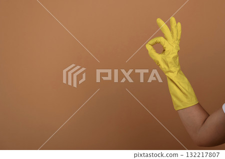 Close up view of woman hand in yellow glove that is showing okay or fine gesture Close up view of woman hand in yellow glove that is showing okay or fine gesture 132217807
