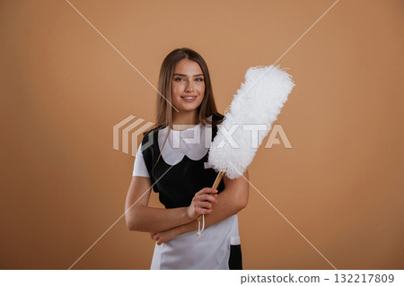 Occupation of chambermaid. Young pretty woman is against background in the studio 132217809