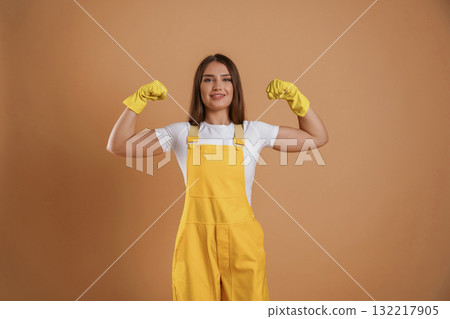 Strong gardener, showing biceps. Young pretty woman is against background in the studio 132217905