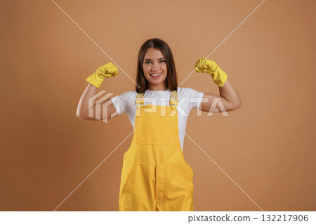 Strong gardener, showing biceps. Young pretty woman is against background in the studio Strong gardener, showing biceps. Young pretty woman is against background in the studio 132217906