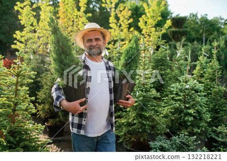 Senior gardener is at work at daytime Senior gardener is at work at daytime 132218221