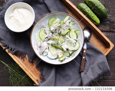 Cucumber with red onion and dill salad in yogurt dressing	 132218306