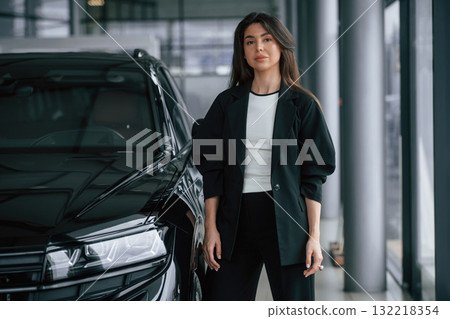 Saleswoman in car showroom, selling automobile Saleswoman in car showroom, selling automobile 132218354