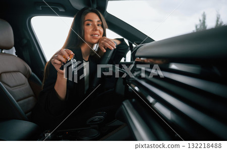 Cheerful, happy new owner with keys. Beautiful businesswoman is in the new car Cheerful, happy new owner with keys. Beautiful businesswoman is in the new car 132218488