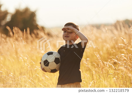 Holding soccer ball. Little boy is having fun outdoors at summertime Holding soccer ball. Little boy is having fun outdoors at summertime 132218579