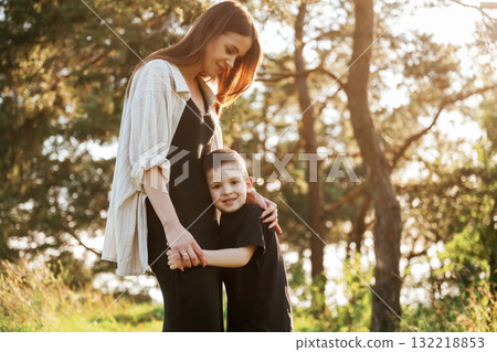 Embracing each other. Mother and son are in the forest together Embracing each other. Mother and son are in the forest together 132218853