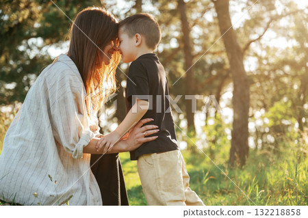 Enjoying the time together. Mother and son are in the forest Enjoying the time together. Mother and son are in the forest 132218858
