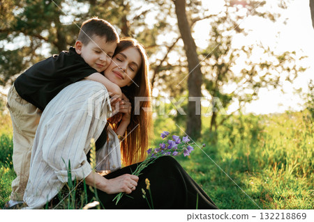 In the sunlight. Mother and son are in the forest together In the sunlight. Mother and son are in the forest together 132218869