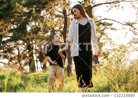 Having a walk. Mother and son are in the forest together Having a walk. Mother and son are in the forest together 132218880