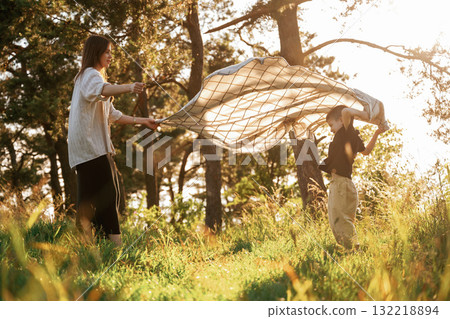 Preparing for picnic, with blanket. Mother and son are in the forest together 132218894