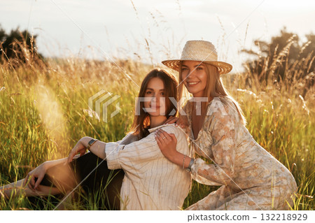 Sitting together. Two women friends are in the rural field 132218929