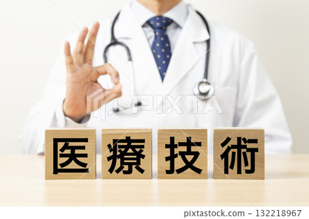 A block with the word "medical technology" written on it and a doctor making an OK sign A block with the word "medical technology" written on it and a doctor making an OK sign 132218967
