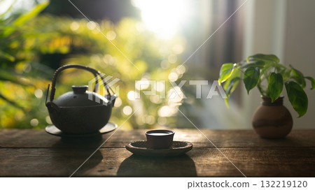 Tea cup and  tea pot on wooden table with pothos plant 132219120