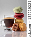 Colorful macarons stacked next to a cup of coffee on a smooth surface in a bright setting 132219221