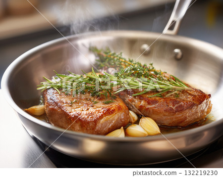 Succulent steak cooking in a skillet with fresh herbs 132219230