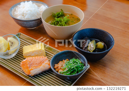 Japanese breakfast of grilled salmon, tamagoyaki (rolled egg), miso soup and natto 132219271