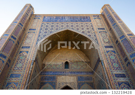 Western iwan of the Bibi-Khanym Mosque is under blue sky. Samarkand Western iwan of the Bibi-Khanym Mosque is under blue sky. Samarkand 132219428