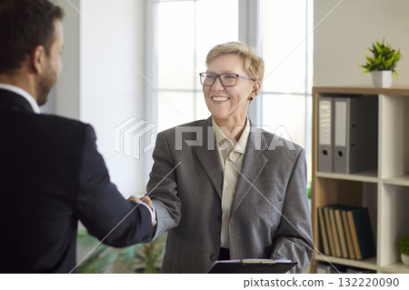 Smiling business partners handshake in office, finalizing deal and partnership Smiling business partners handshake in office, finalizing deal and partnership 132220090