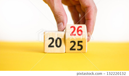 Business concept of 2026 new year symbol. Businessman turns wooden cube and changes number 2025 to 2026. Beautiful white and yellow background, copy space. Business 2026 happy new year concept. 132220132