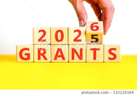 2026 Grants symbol. Concept words 2026 Grants on beautiful wooden blocks. Beautiful white and yellow paper background. Businessman's hand. Business and 2026 grants concept. Copy space. 132220164