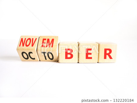 Symbol for the change from October to November. Businessman turns wooden cubes and changes the word October to November. Beautiful white background. Happy November concept. Copy space. Symbol for the change from October to November. Businessman turns wooden cubes and changes the word October to November. Beautiful white background. Happy November concept. Copy space. 132220184