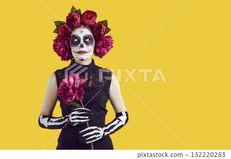 Close up portrait of young woman in stage halloween make-up isolated on yellow background. 132220283