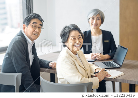 Smiling senior businessman and customer in a conference room Smiling senior businessman and customer in a conference room 132220439