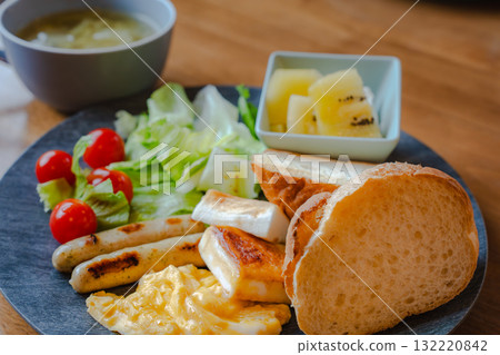 Western-style breakfast of bread, scrambled eggs, salad and fruit Western-style breakfast of bread, scrambled eggs, salad and fruit 132220842