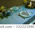 Elegant tableware is arranged for the special occasion, with a folded napkin sitting perfectly on each plate as a finishing touch. 132221990