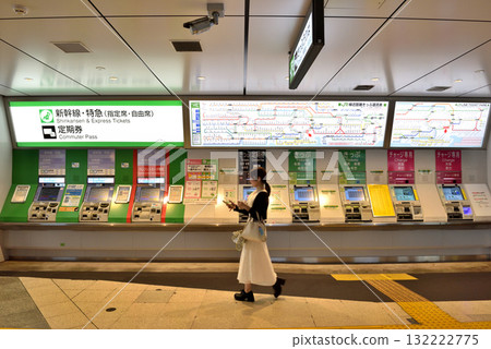 A woman walking in front of the ticket counter at JR Shinbashi Station A woman walking in front of the ticket counter at JR Shinbashi Station 132222775