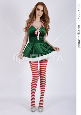 Beautiful, tall, shapely, redhead model dressed as Santa's Sexy Helper in a green velvet dress and candy-stripe stockings Beautiful, tall, shapely, redhead model dressed as Santa's Sexy Helper in a green velvet dress and candy-stripe stockings 132223220